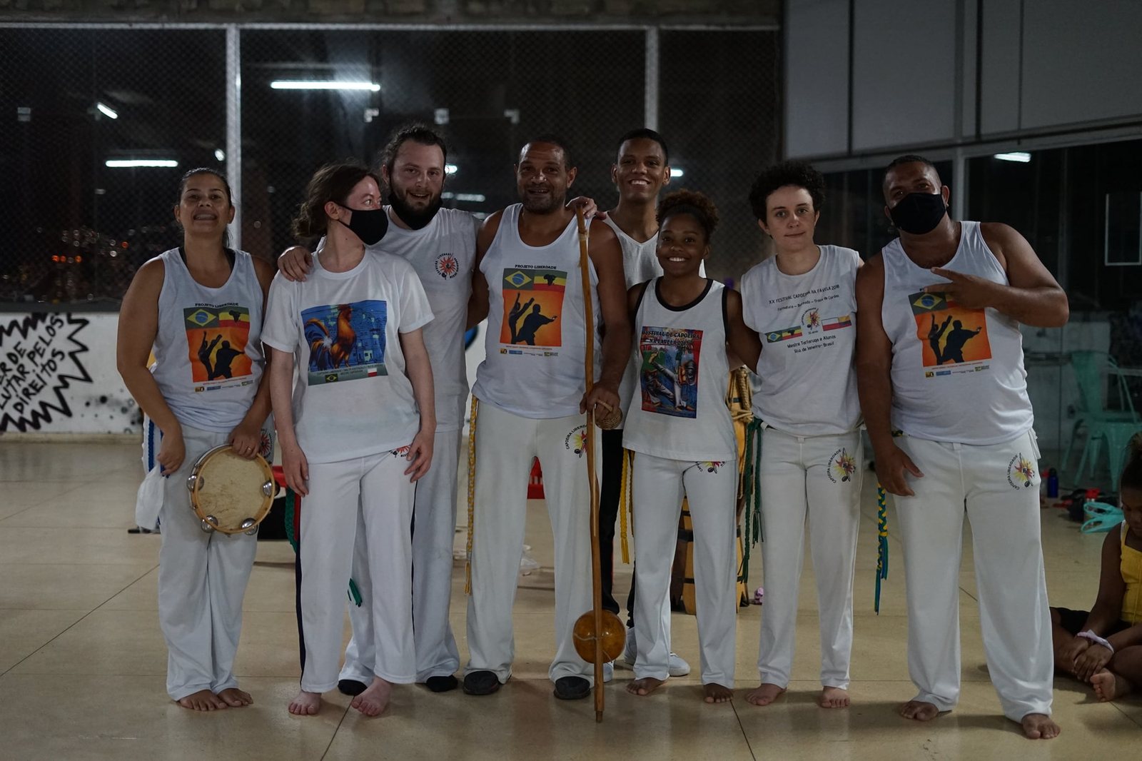 Grupo de capoeiristas adultos com pandeiro e berimbau
