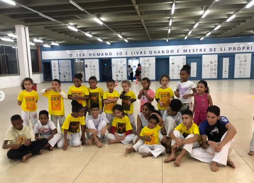 Crianças da turma infantil sentadas no ginásio