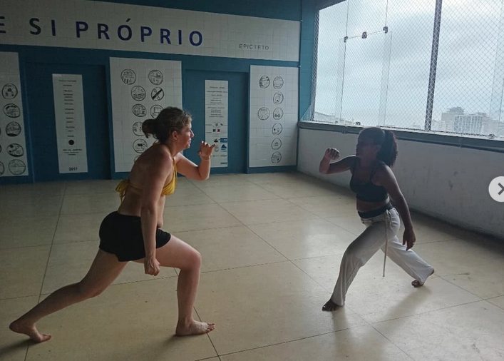 Duas alunas adultas treinando movimentos de capoeira